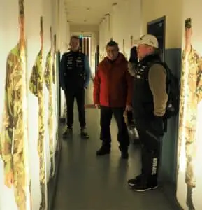 Mit Spaß bei den Dreharbeiten: Joey Kelly übt den soldatischen Gruß in der Baracke A des ehemaligen US Camps. Die korrekte Haltung überprüfen sein Sohn Luke (hinten, links) und der frühere Command Sergeant Major Vern Croley.