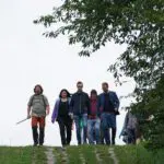Die Wanderer laufen auf den Lochbetonplatten des ehemaligen Kolonnenweges.