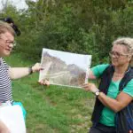 Wie aufwendig die Freihaltung der Wege ist, machen Corinna Hoßfeld (li.) und Julia Gombert anhand von Vorher-/Nachher-Fotos deutlich.