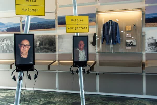 In der Dauerausstellung im Haus auf der Grenze stehen neben den Ortsschildern Monitore mit Kopfhörern. In Videos erzählen Zeitzeugen aus der Region ihre persönlichen Geschichten.