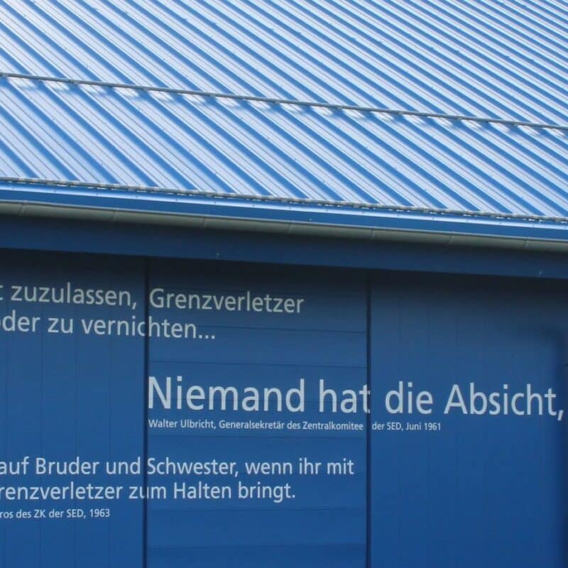 „Niemand hat die Absicht…“: Zitate und Aussagen, die im Zusammenhang mit der Innerdeutschen Grenze stehen, prangern als Mahnung an der Außenfassade am Haus auf der Grenze.
