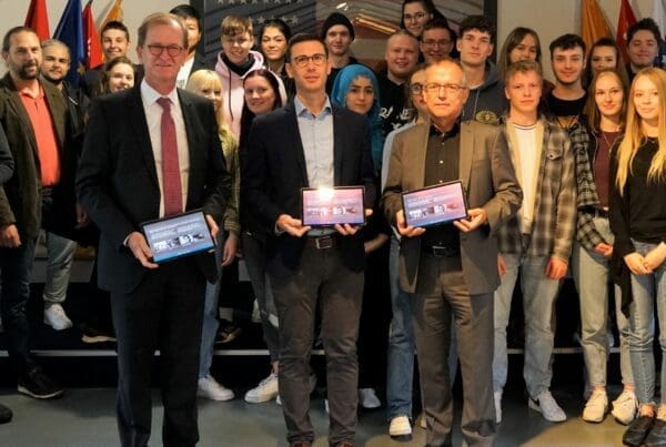 Matthias Haupt, Geschäftsführer der Sparkassen-Kulturstiftung Hessen-Thüringen (vorne rechts), und Horst Habermehl, Mitglied des Vorstandes der Sparkasse Fulda (vorne links), übergaben im Rahmen des ersten Lernapp-Workshops im US Camp der Gedenkstätte 15 Tablets an den Geschäftsführenden Vorstand der Point Alpha Stiftung, Sebastian Leitsch (Mitte).