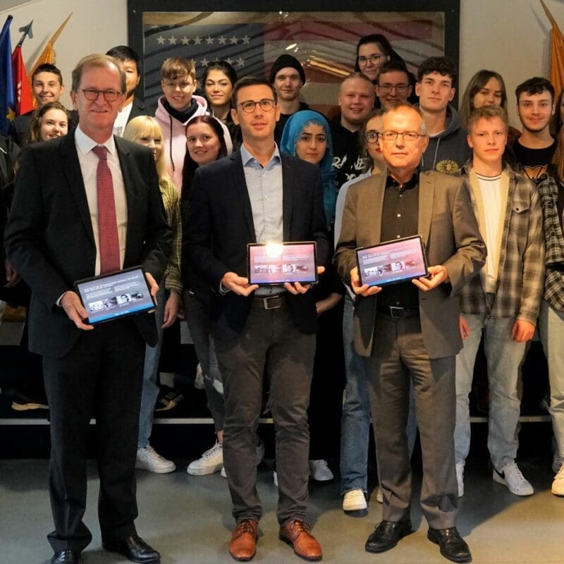 Matthias Haupt, Geschäftsführer der Sparkassen-Kulturstiftung Hessen-Thüringen (vorne rechts), und Horst Habermehl, Mitglied des Vorstandes der Sparkasse Fulda (vorne links), übergaben im Rahmen des ersten Lernapp-Workshops im US Camp der Gedenkstätte 15 Tablets an den Geschäftsführenden Vorstand der Point Alpha Stiftung, Sebastian Leitsch (Mitte).