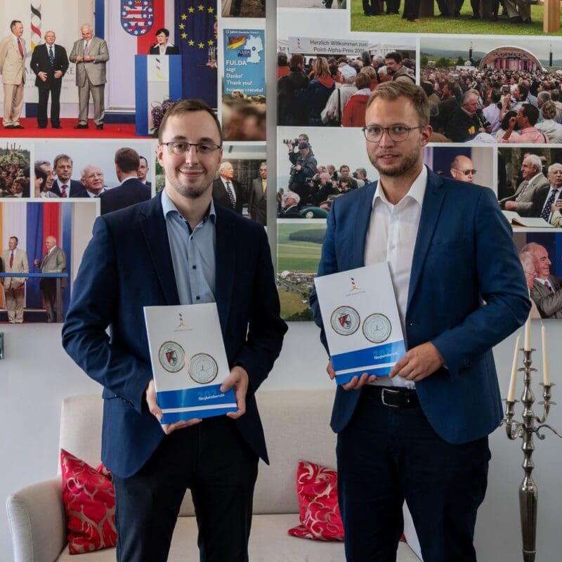 Druckfrisch: Der Vorstand der Point Alpha Stiftung mit Benedikt Stock (rechts) und Philipp Metzler präsentieren den Geschäftsbericht für das Jahr 2025.